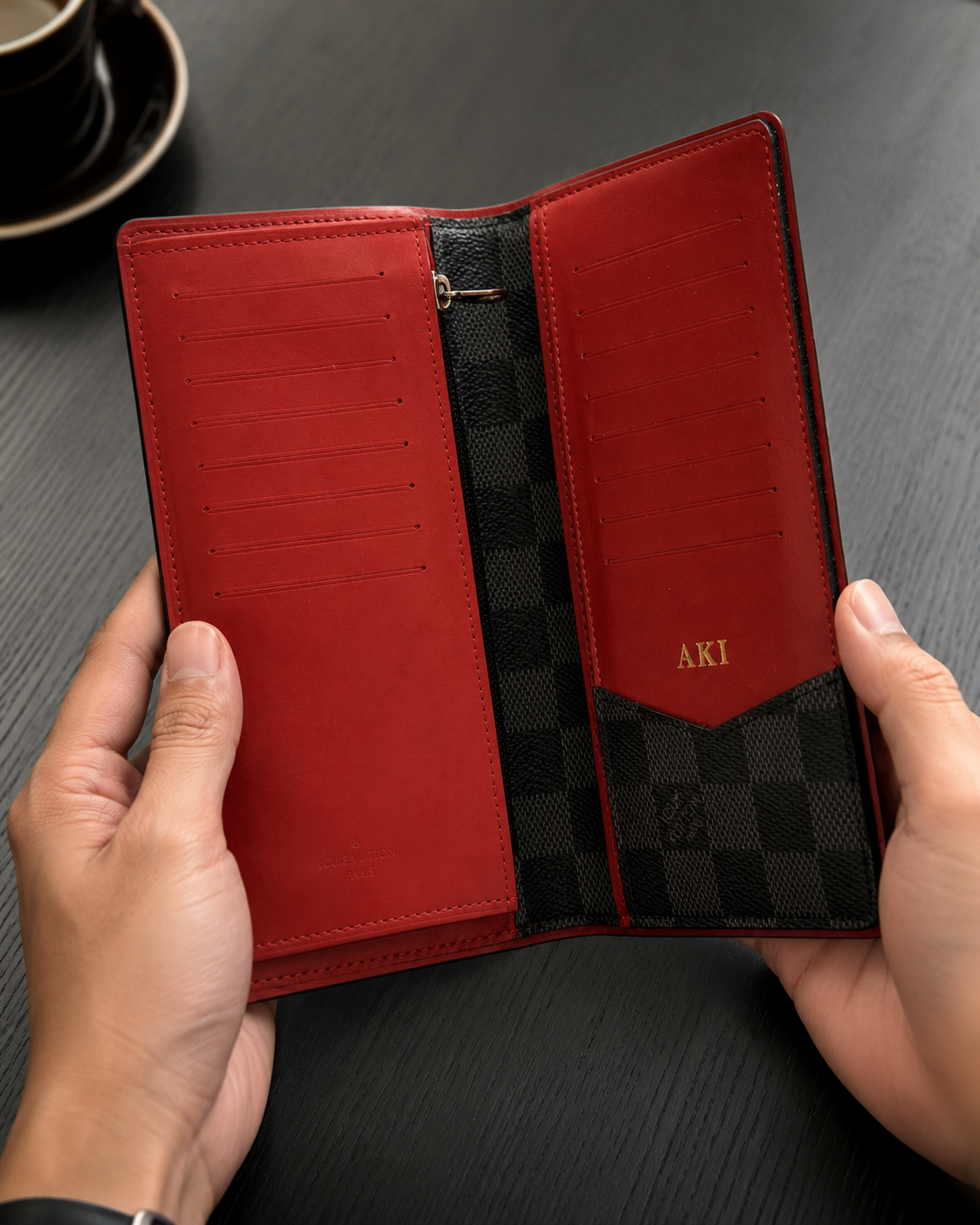 Louis Vuitton long wallet crafted in black and grey Damier Graphite coated canvas with contrasting red leather trim.