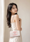Chanel Beauty Bag features a white patent leather exterior with a prominent pink logo design