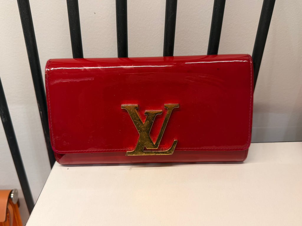 Louis Vuitton long wallet crafted in glossy red patent leather with a large gold-tone LV logo on the front.