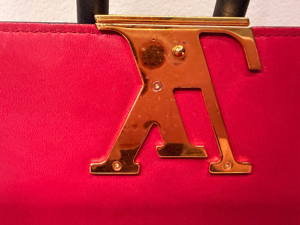 Louis Vuitton long wallet crafted in glossy red patent leather with a large gold-tone LV logo on the front.