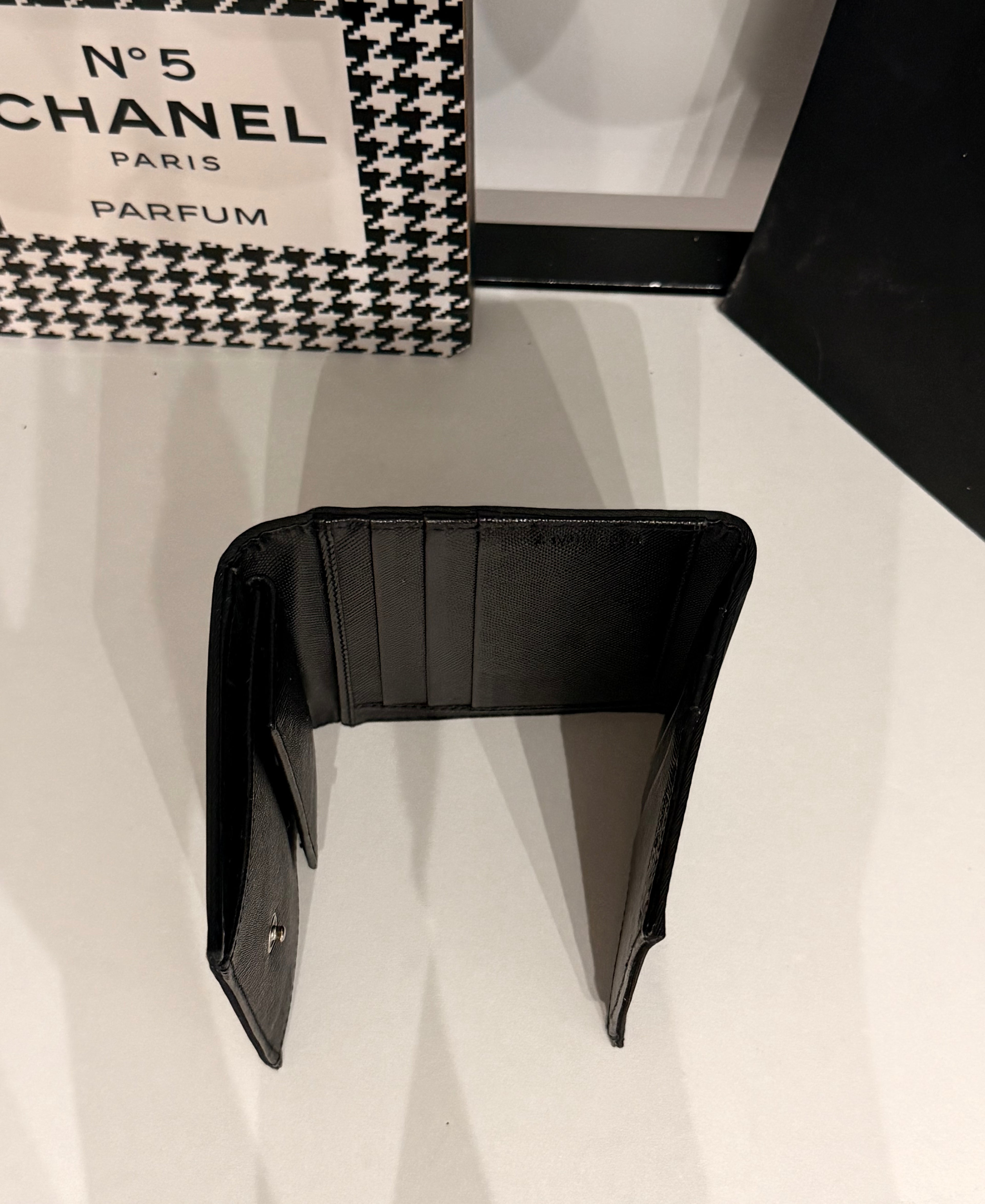 Classic Prada compact wallet crafted from durable black Tessuto nylon and finished with the iconic silver-tone triangular Prada Milano logo plaque.
