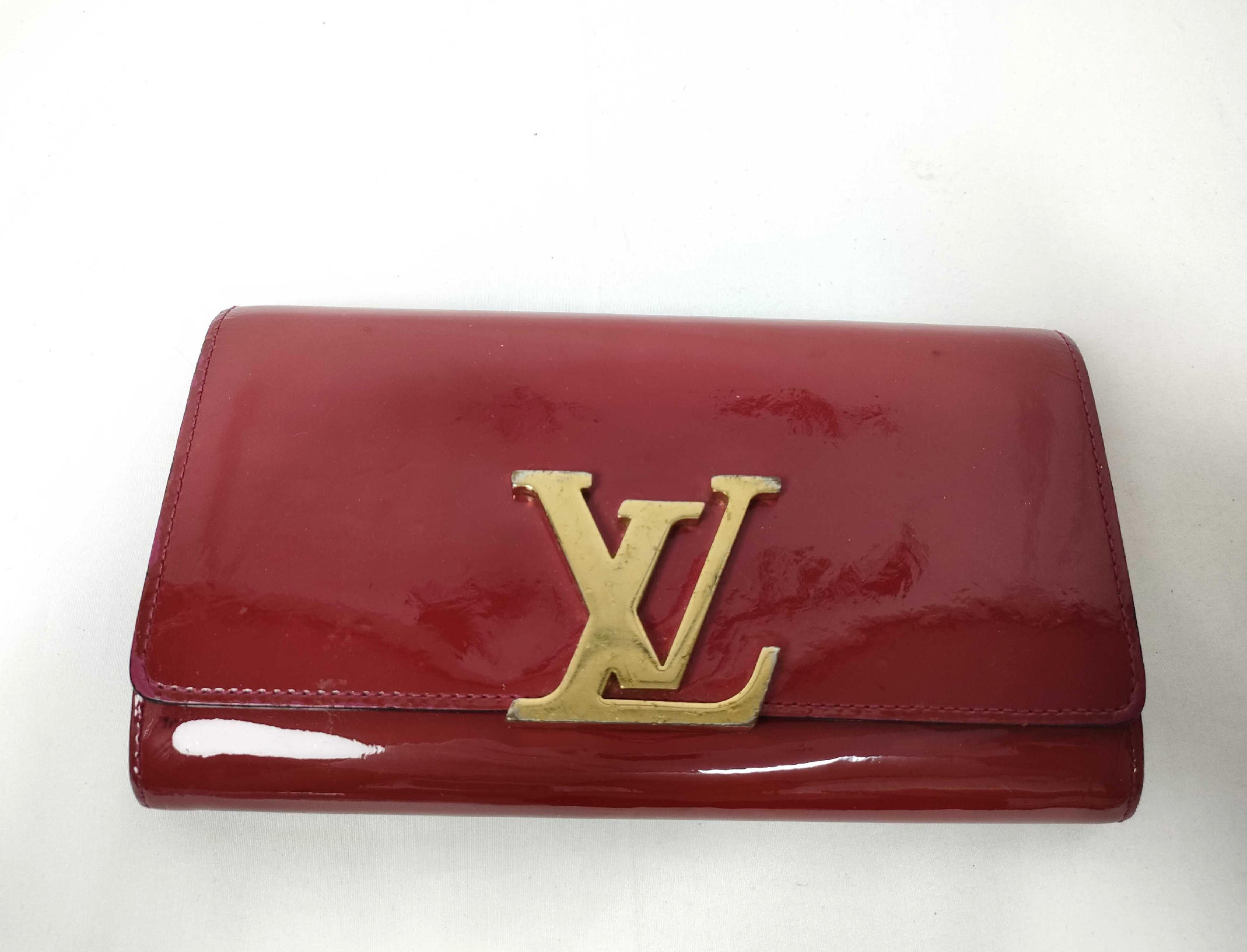 Louis Vuitton long wallet crafted in glossy red patent leather with a large gold-tone LV logo on the front.