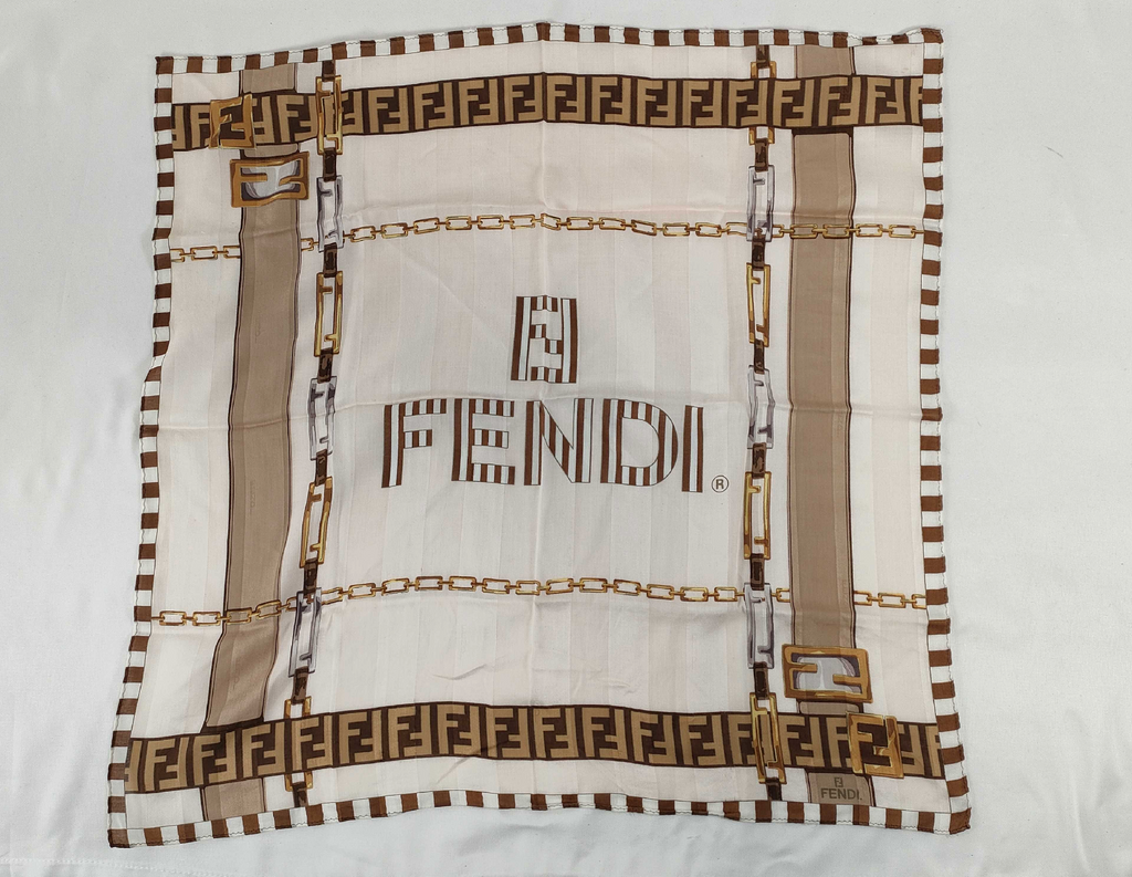 Fendi scarf featuring the iconic FF monogram, belt and chain motifs in soft beige, cream, brown, and gold tones.