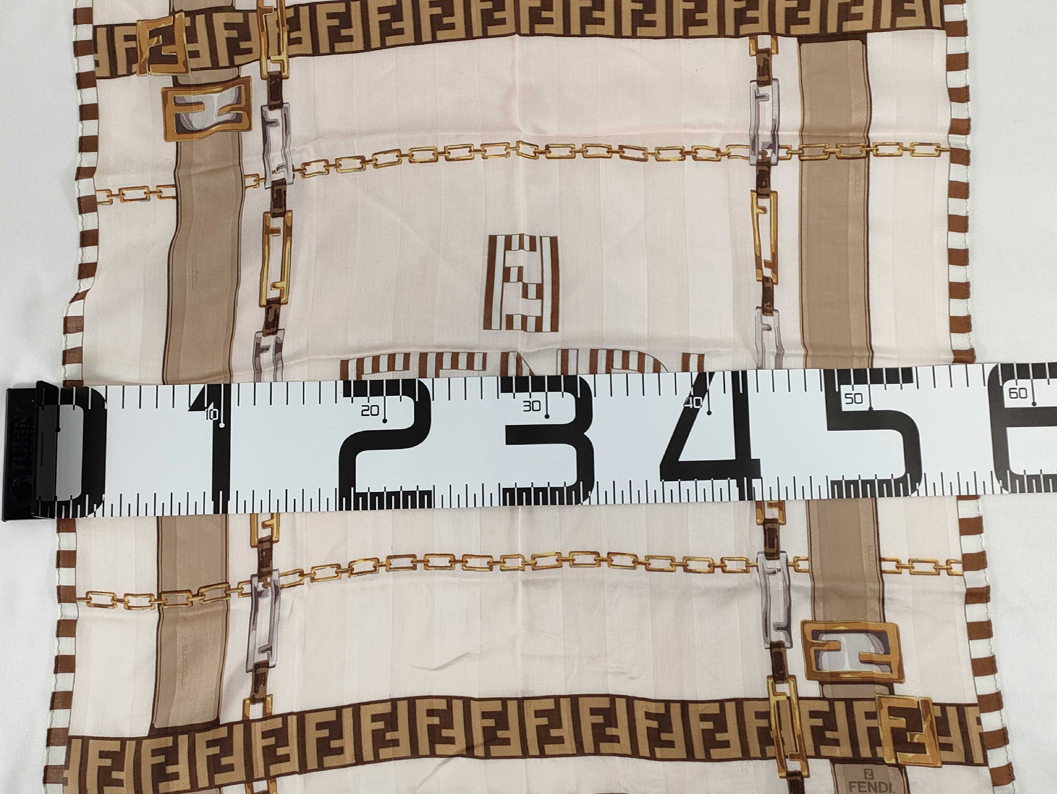 Fendi scarf featuring the iconic FF monogram, belt and chain motifs in soft beige, cream, brown, and gold tones.