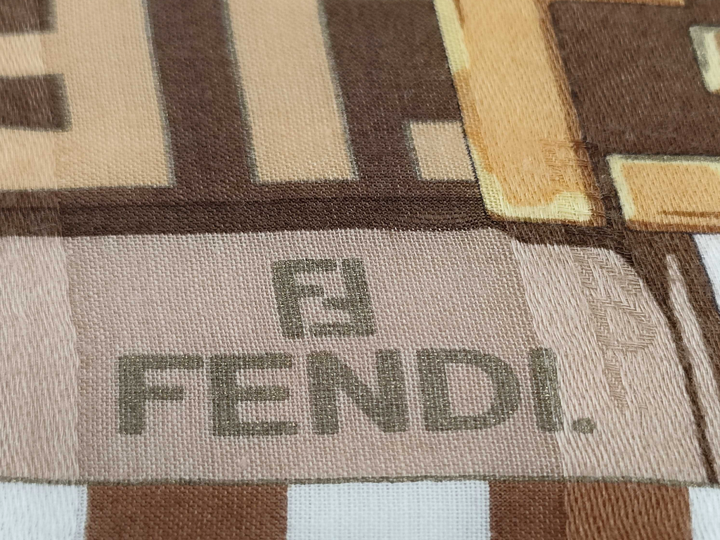 Fendi scarf featuring the iconic FF monogram, belt and chain motifs in soft beige, cream, brown, and gold tones.