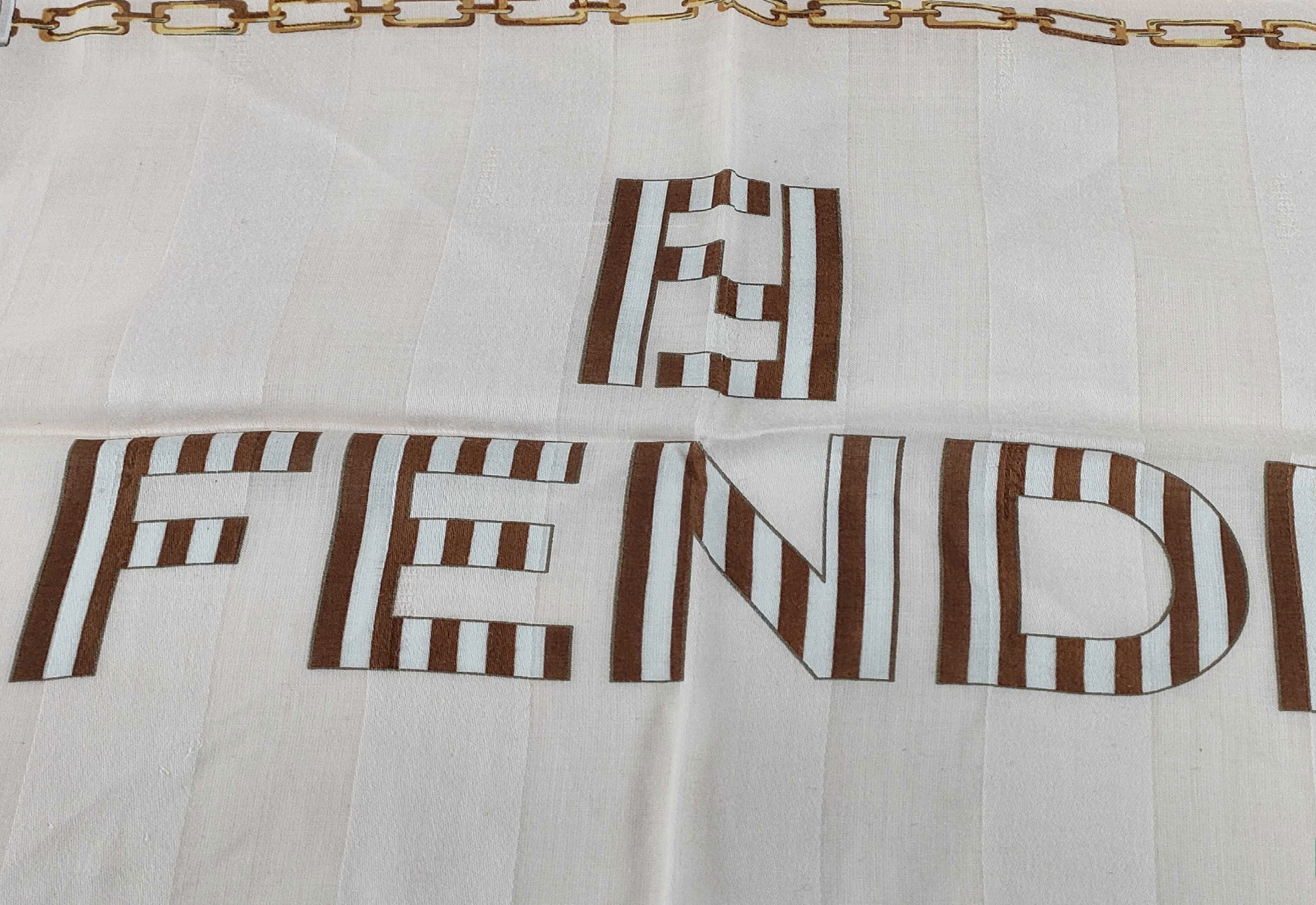 Fendi scarf featuring the iconic FF monogram, belt and chain motifs in soft beige, cream, brown, and gold tones.