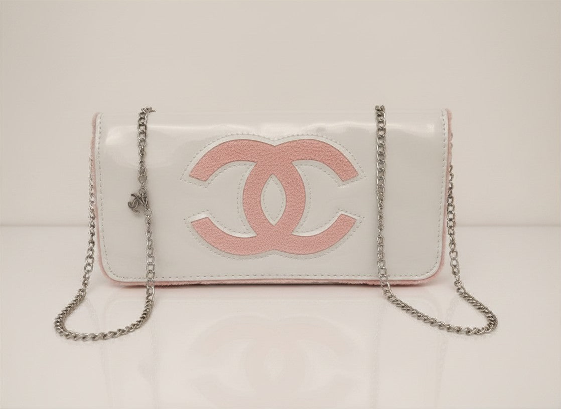 Chanel Beauty Bag features a white patent leather exterior with a prominent pink logo design