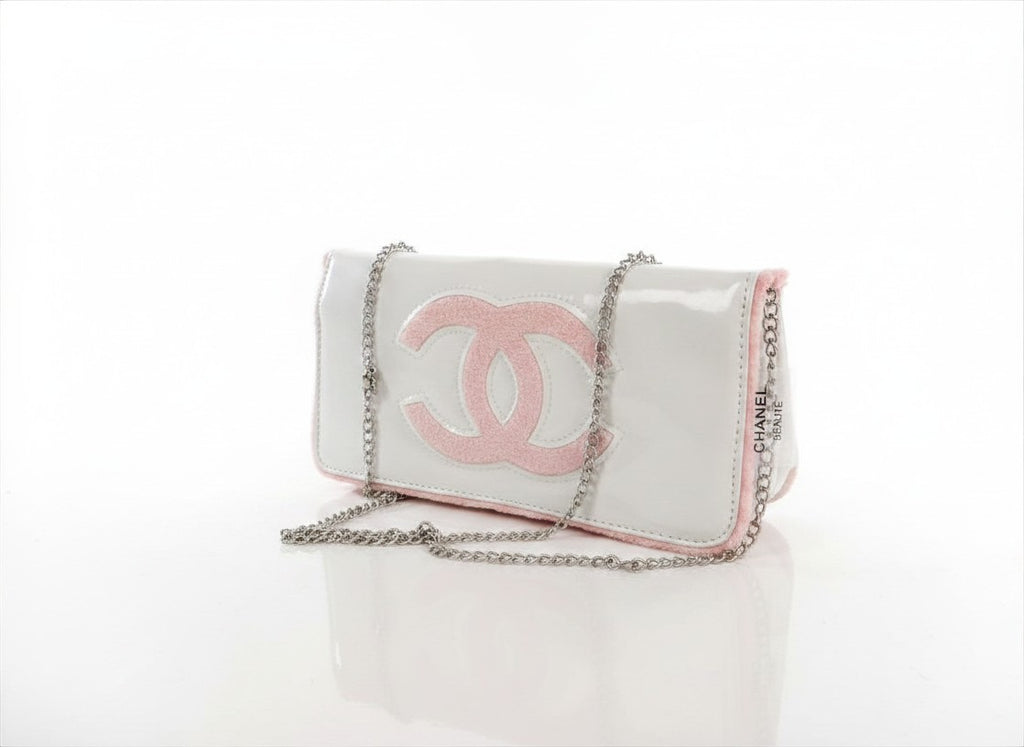 Chanel Beauty Bag features a white patent leather exterior with a prominent pink logo design
