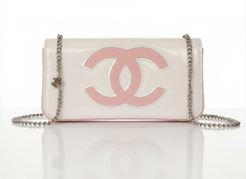 Chanel Beauty Bag features a white patent leather exterior with a prominent pink logo design