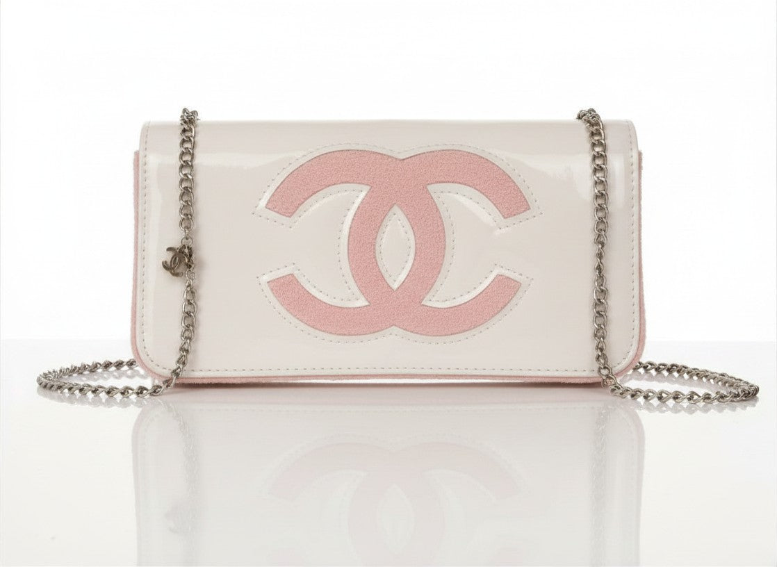 Chanel Beauty Bag features a white patent leather exterior with a prominent pink logo design
