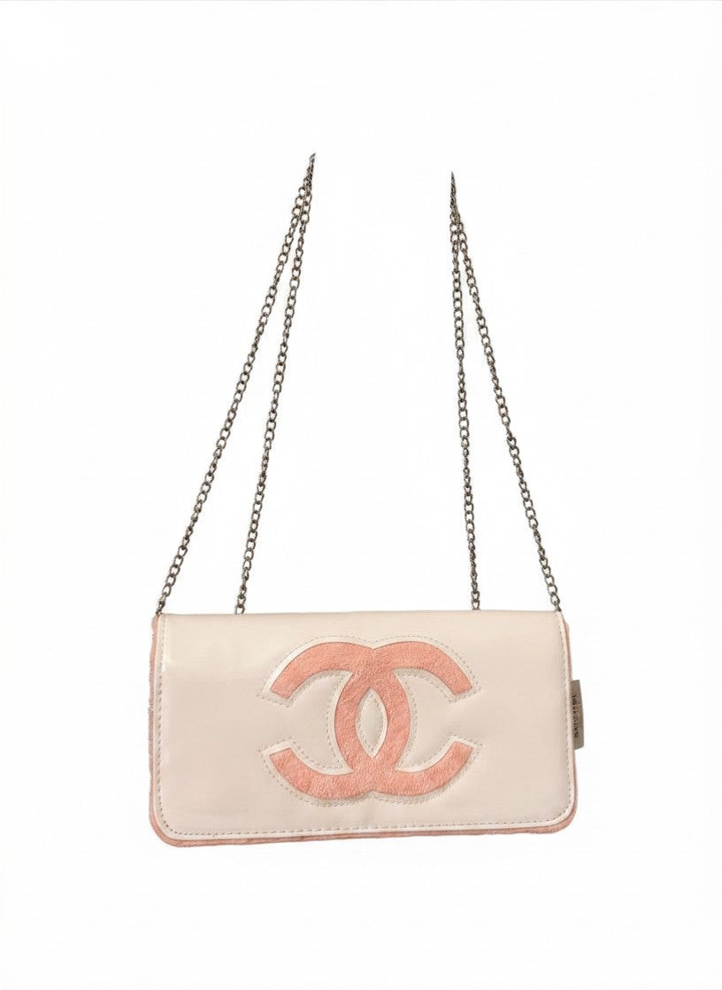 Chanel Beauty Bag features a white patent leather exterior with a prominent pink logo design