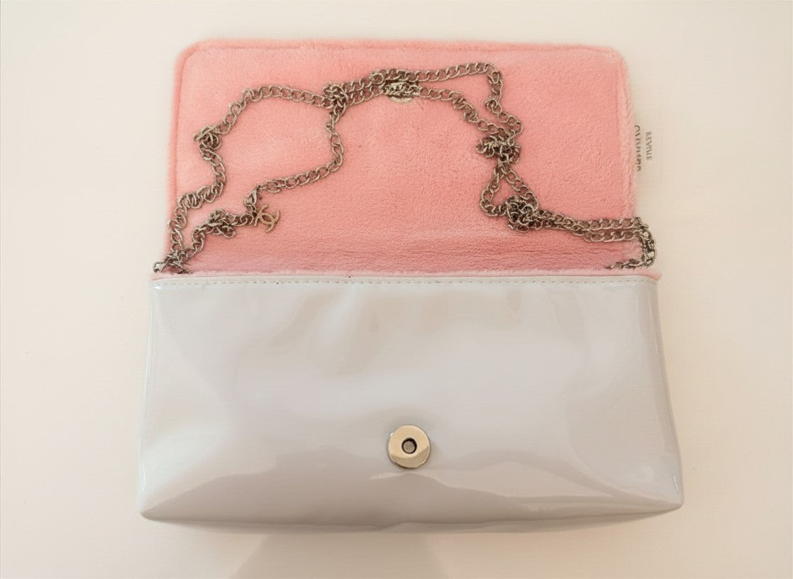 Chanel Beauty Bag features a white patent leather exterior with a prominent pink logo design